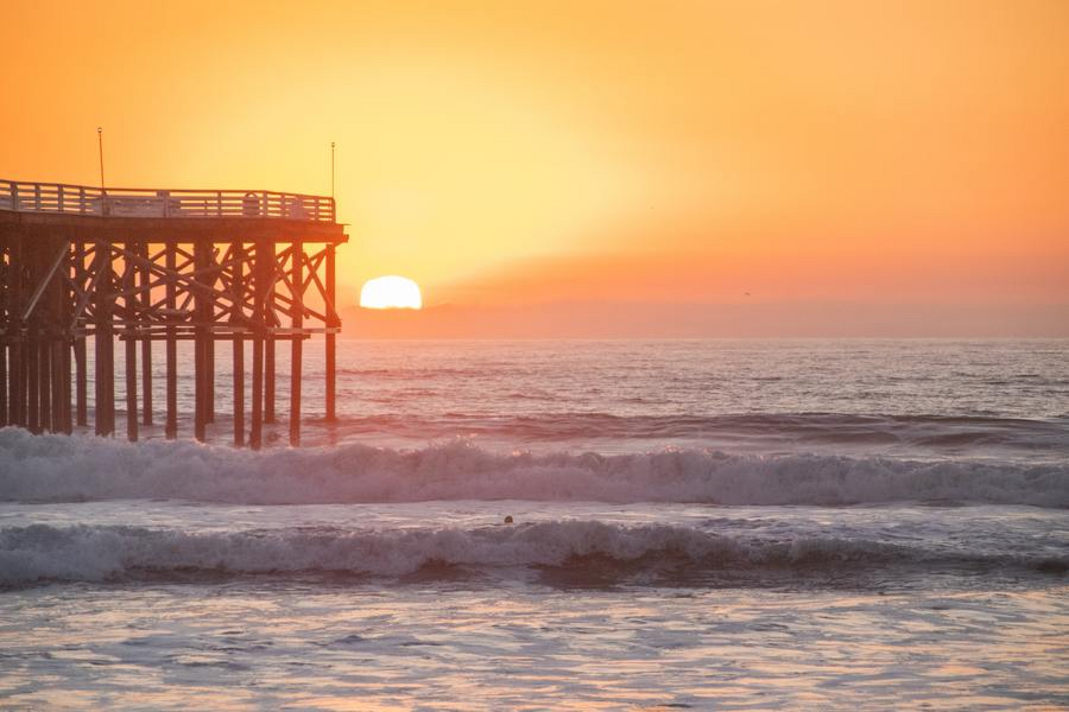 sunset over pier at beach